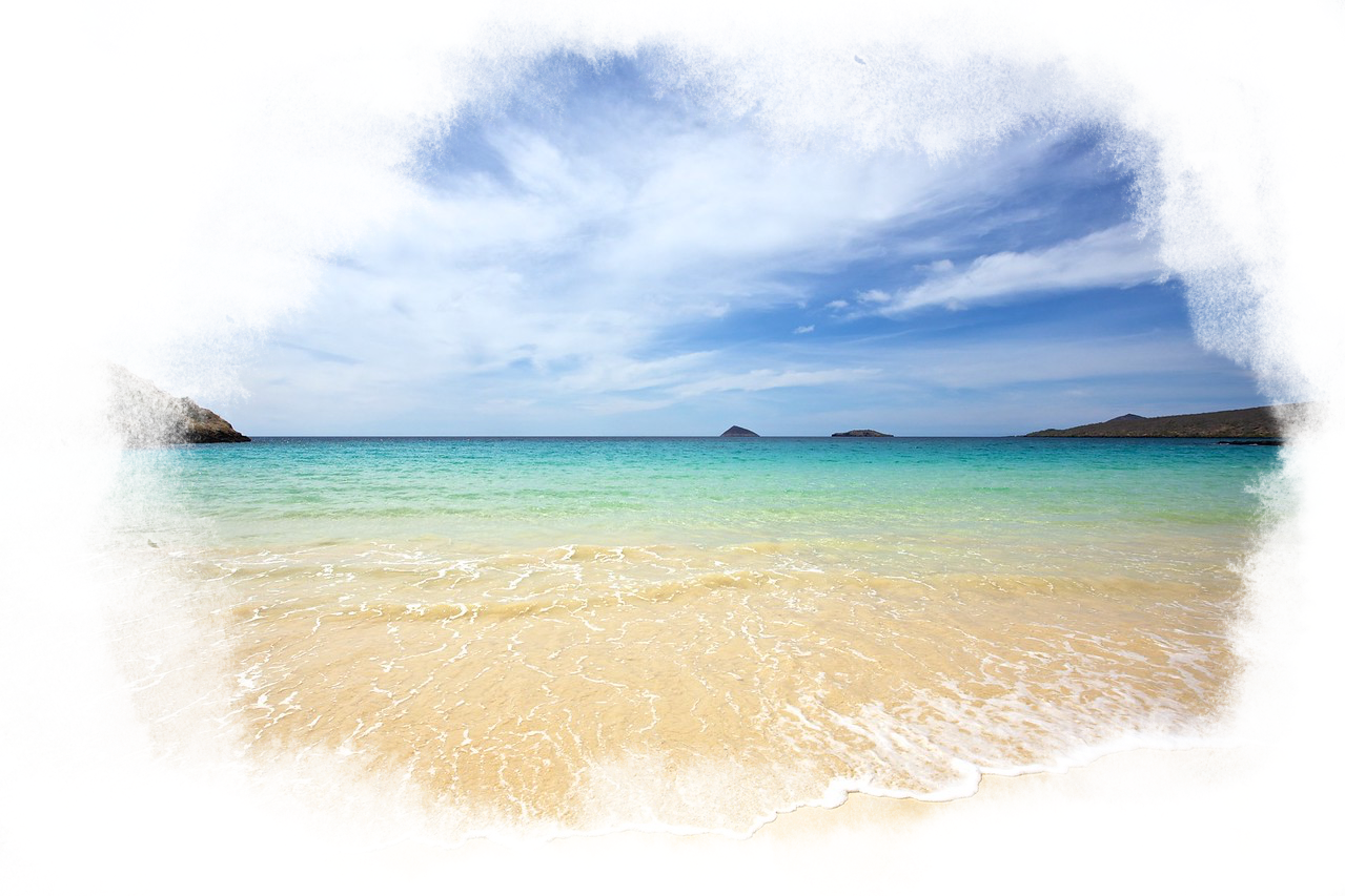 A white sandy beach with clear blue water.