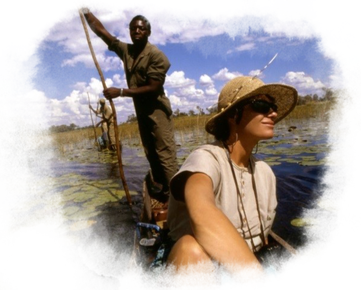 A man guides a canoe for a woman.