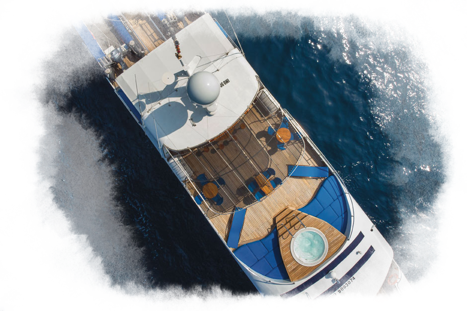 A birds-eye view of the top deck of the integrity ship. There is a hot tub, lounge chairs and tables on the deck.
