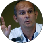 Arturio Izurieta, speaking into a microphone at a conference.