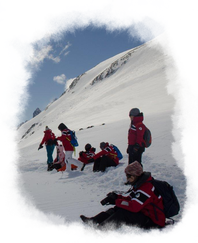 A group of travelers sit in the snow.